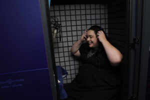 Maria Pendolino putting on her headphones in her recording booth