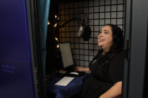 Maria Pendolino in her booth recording audio behind the scenes.