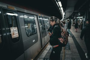 transit announcement voice heard on a subway platform with a passenger waiting for the train doors to open